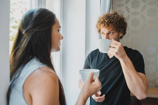 istock Young couple drinking coffee in their new apartment and talking 1159473989