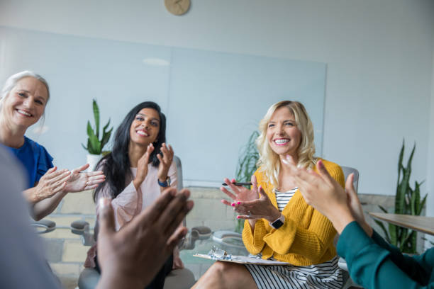 istock Diverse adults applauding success of person during support group therapy session 1159477422