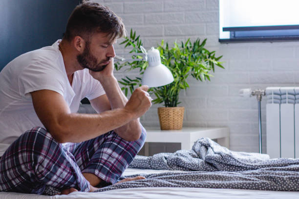 istock a young man feels pain in the head and fever 1159479215