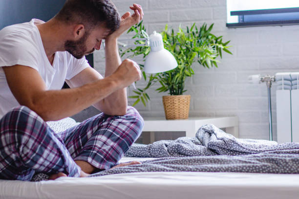 istock a young man feels pain in the head and fever 1159479216