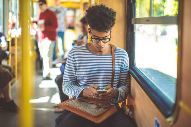 Checking messages Young man checking messages on his smart phone bus hungary stock pictures, royalty-free photos & images