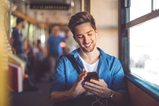 Checking messages Young man checking messages on his smart phone bus hungary stock pictures, royalty-free photos & images