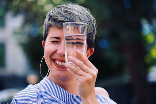 Woman looking through a glass of water