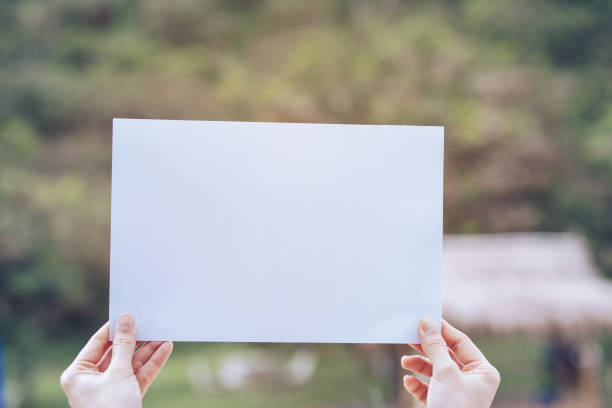 istock Show business paper in hand on nature background 1159480698