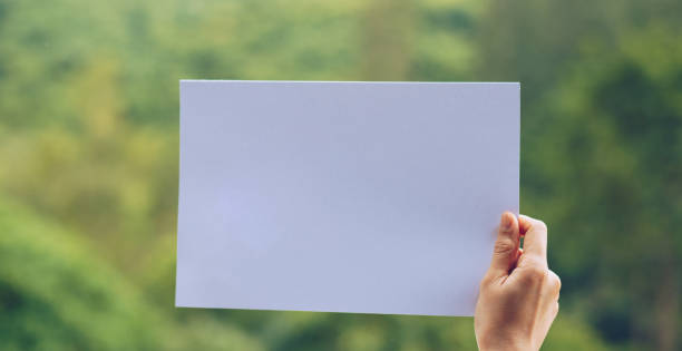 istock Show business paper in hand on nature background 1159480700