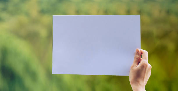 istock Show business paper in hand on nature background 1159480701