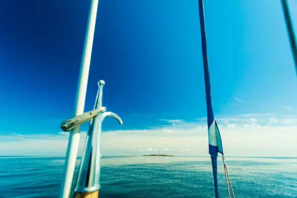 Boat hook on sailboat deck yacht, outdoor shot on blue sky background.