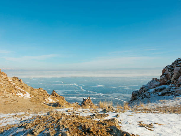Photo of Landscape of frozen Lake Baikal in winter with background of hills and blue sky from view point cape at Olkhon island.