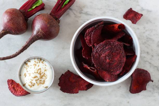 istock Healthy beet chips, top view over a white marble background 1159484758