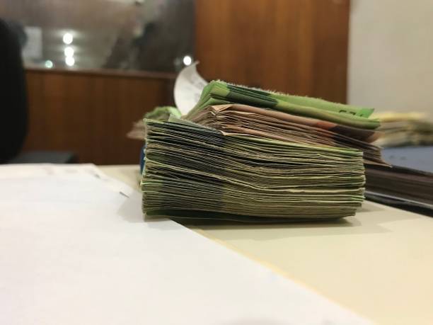 istock Many mexican peso money bills stacked on a beige coloured table 1159485878