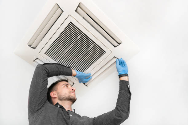 Young technician repairing air conditioner Handsome young technician repairing air conditioner. Installing air conditioning system. cool climate stock pictures, royalty-free photos & images