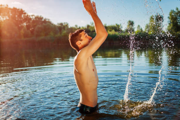 istock Young man in water and making splash. Summer vacation 1159487307