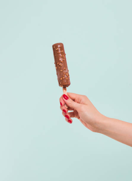 Female hand holding ice cream in waffle cone