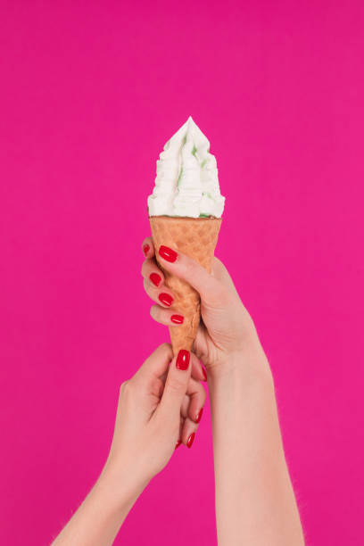 istock Female hand holding ice cream in waffle cone 1159488358