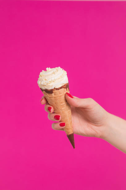 istock Female hand holding ice cream in waffle cone 1159488359
