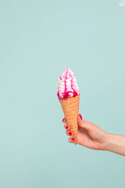 istock Female hand holding ice cream in waffle cone 1159488367