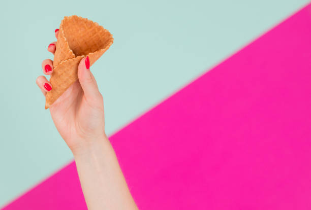 istock Female hand holding empty wafer cone for ice cream 1159488375