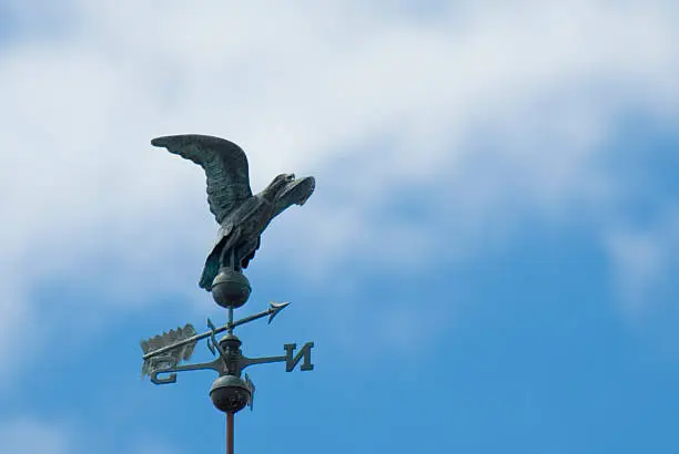 A bronze eagle sits atop this decorative weather vane