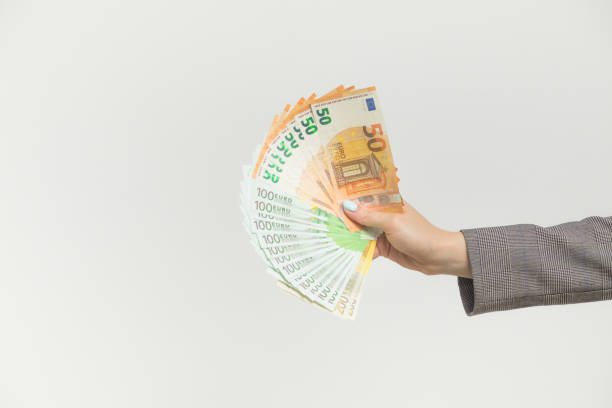 istock Female hands holding euro banknotes on a white background. 1159490871