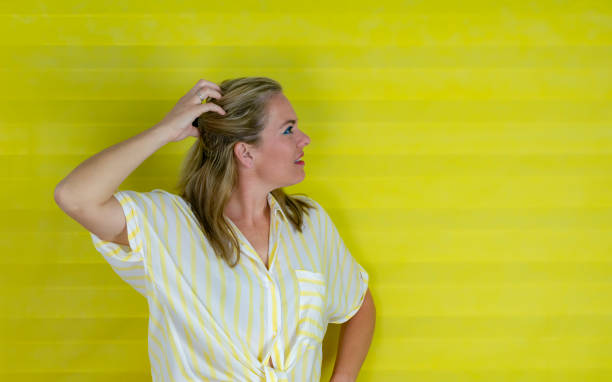 young hispanic woman over isolated background confuse and wonder about question. Uncertain with doubt, thinking with hand on head