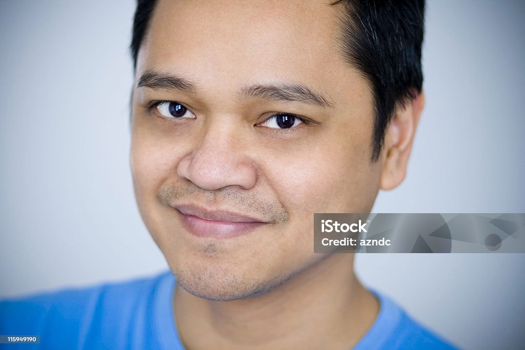 Handsome Asian Male Close-up of attractive Asian man smiling and wearing a blue shirt. 30-39 Years Stock Photo