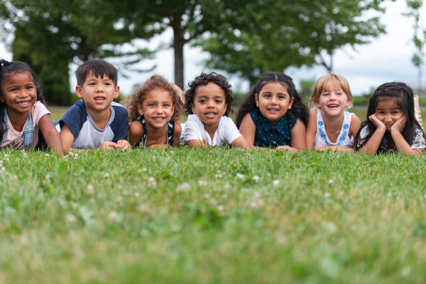 istock Multi-Ethnic Group of Kindergarten Kids Lying in the Grass 1159495567