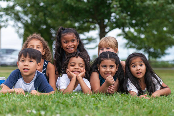 istock Multi-Ethnic Group of Kindergarten Kids Lying in the Grass 1159495568