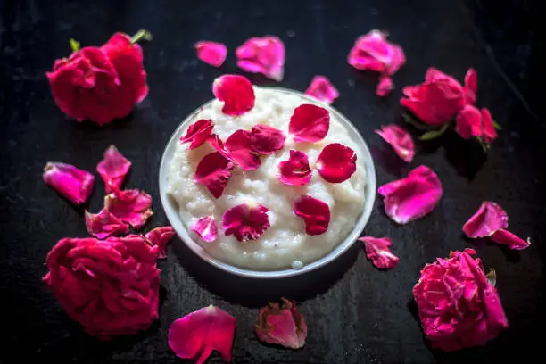 Popular Indian & Asian Ramadan dish or Ramazan dessert i.e Kheer in a glass plate along with some rose flowers and petals on it.