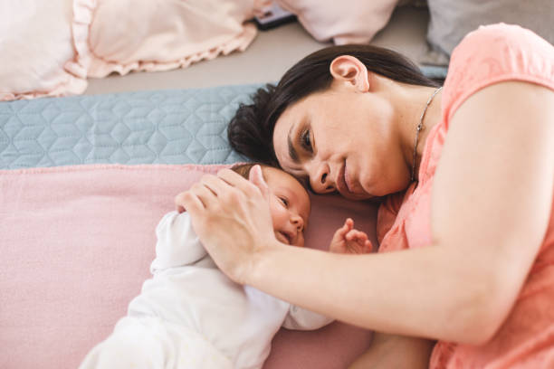 istock Mother cuddling with her newborn daughter 1159495904