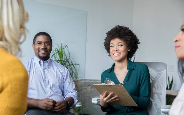istock Diverse adults meeting in support group and smiling 1159496045