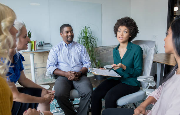 istock Diverse adults listening to therapist during support group therapy session 1159496049