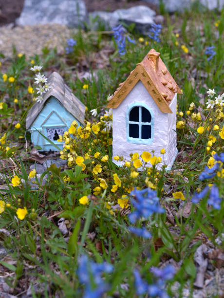 istock Two fairy houses and spring flowers, vertical. 1159500406