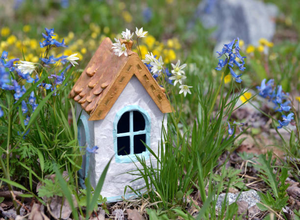 istock Small white fairy house in grass. 1159500505