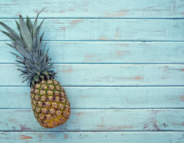 istock Tropical pineapple on retro light blue would picnic bench 1159507916