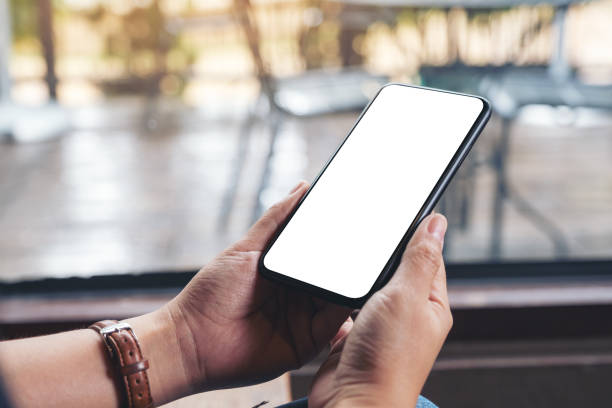 istock woman's hands holding black mobile phone with blank desktop screen 1159507997