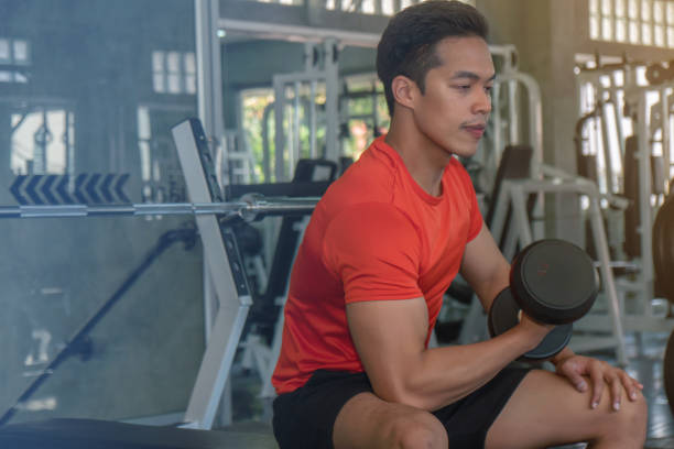 istock male having exercise lifting dumbbell in gym 1159508274
