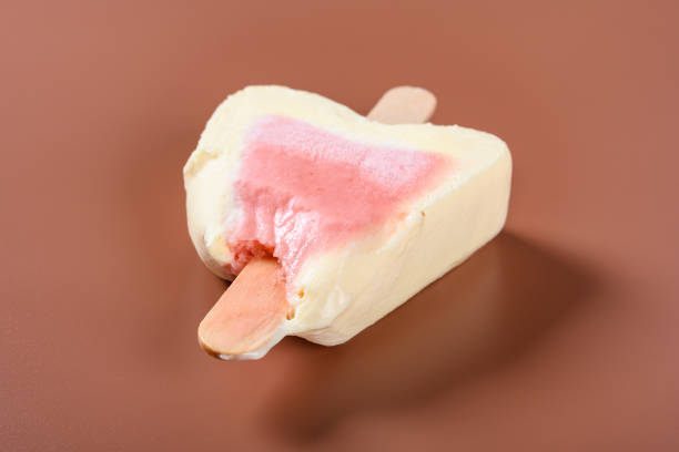 istock side view half eaten strawberry flavor popsicle on a brown background 1159511866