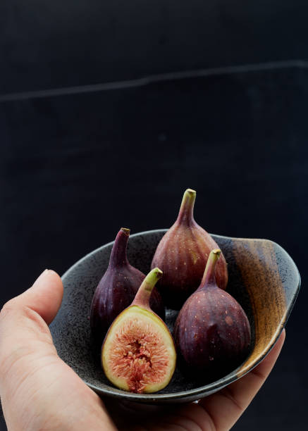 istock Holding plate with cut ripe figs organic food 1159514322