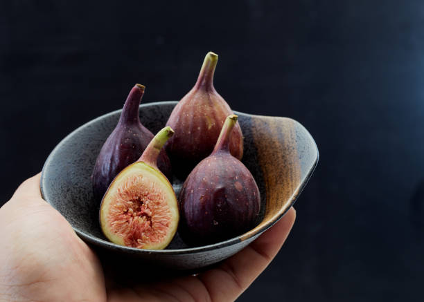 istock Holding plate with cut ripe figs organic food 1159514419