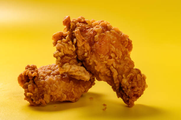 side view fresh deep fried chicken drumstick and wing on yellow background stock photo