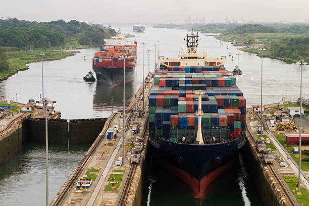 Cargo Ship in Panama Canal Several freighters, assisted by tugboats, are entering the Panama Canal at Gatun Locks on the Atlantic side. These container ships are fully loaded with cargo heading west towards the Pacific. canal stock pictures, royalty-free photos & images