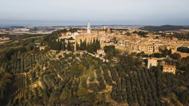 Photo of Aerial panoramic drone view of Pienza old town in Tuscany, Italy. San Quirico d'Orcia region. Olive gardens and agriculture fields around. Autumn view.
