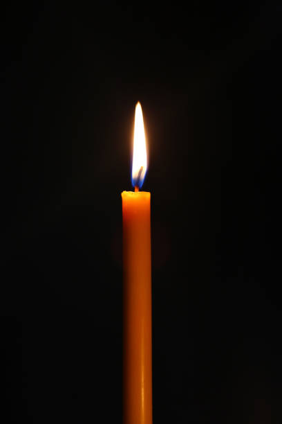 istock One candle burning brightly in the dark. 1159520010