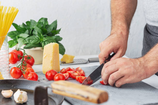 istock Chef cooking pasta with tomatoes in kitchen 1159521930