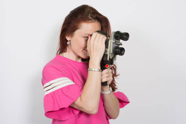 Portrait of a woman with retro movie camera isolated on white background Portrait of a woman with retro movie camera isolated on white background. vintage amateur movie camera stock pictures, royalty-free photos & images