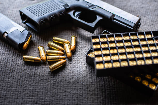 balles et pistolet sur le bureau de velours noir - handgun gun blue black photos et images de collection