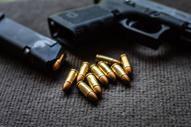 istock bullets and gun on black velvet desk 1159526994