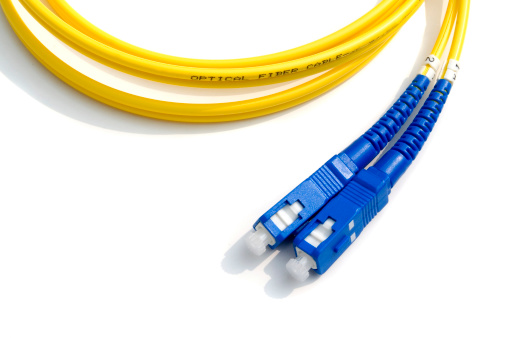 Yellow optical fiber cable isolated on white.