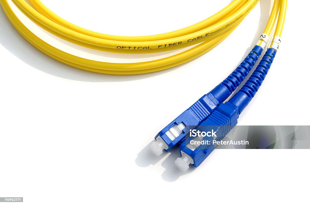 Optical Fiber Cable - Yellow with Blue Connectors Yellow optical fiber cable isolated on white. Fiber Optic Stock Photo