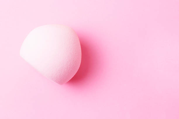 istock Makeup sponge isolated on pink background close-up, top view. 1159531359